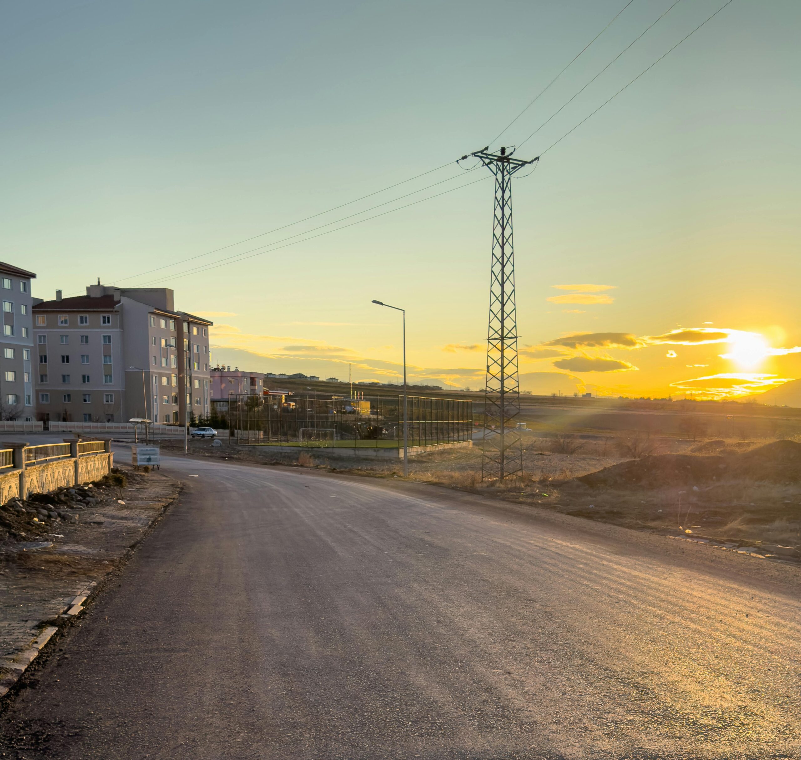 Beautiful sunset over a quiet road in Palu, Elazığ, with buildings and powerline.